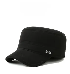 Detail of a black flat top winter cap with reinforced stitching and metal ornament