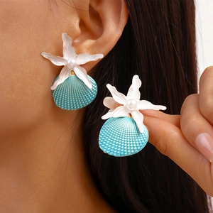 Tropical sea star and pearl drop earrings on a model for a beach vacation look