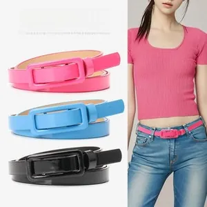 Close-up of fashionable glossy patent leather women's belts with matching square buckles
