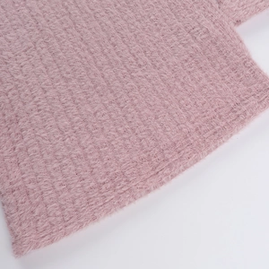 Gros plan sur la maille rose pelucheuse et douce de la robe moulante à épaules nues
