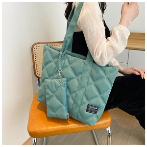 Close-up of green quilted nylon tote bag featuring a matching small coin purse and soft fabric