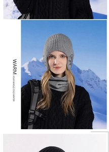 Detail of grey knitted winter hat and neck warmer set with snowflake ear protection