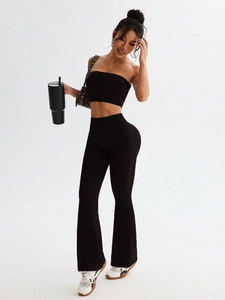 Detail of high-waisted flared leggings and crop top set in black seamless elastic knit
