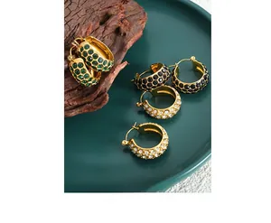 Macro shot of vintage gold hoops with pave-set green, black, and white zircon crystals