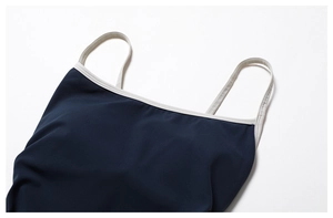 Détail de la combinaison de yoga avec bretelles crème contrastées et tissu bleu marine