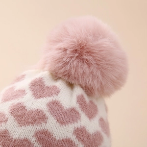 Rosa Strickmütze für Babys mit Herzmuster und großem flauschigem Kunstpelz-Pompon