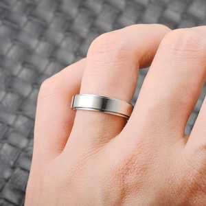 Close-up of minimalist silver titanium steel ring shown on finger with polished finish
