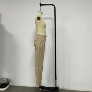 Detail view of khaki wide-leg trousers featuring cargo side pockets and decorative buttons