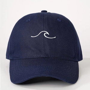 Close-up of white wave embroidery and stitching on deep blue cotton baseball cap