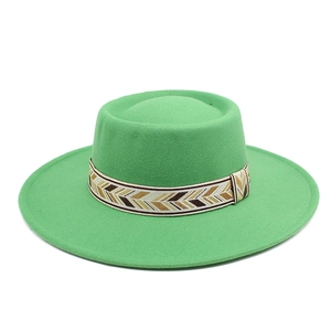 Detailed texture of green wool felt flat brim hat with ethnic geometric patterned band
