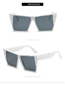 Detail of square oversized sunglasses featuring black and white splatter pattern frames