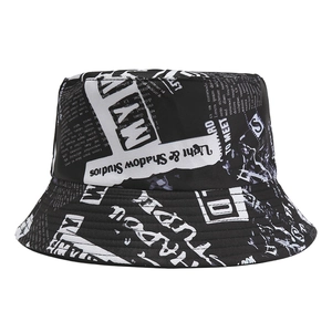 Detailed view of the black fisherman hat featuring white newspaper print and canvas texture