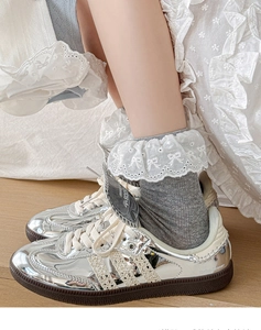 Gros plan de chaussettes grises en tricot avec bordure en dentelle blanche et nœud