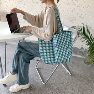 Detail shot of the large capacity blue and white plaid woven tote bag with shoulder strap
