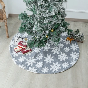 Gray Christmas tree skirt with white snowflake patterns on a rustic wooden floor