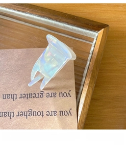 Detail view of mini iridescent white acetate claw clip on a rustic wooden background