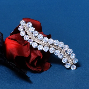Sparkling silver hair clip with round zircons in wavy design on blue background