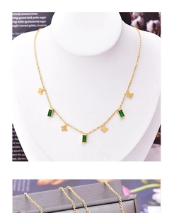 Detail of gold butterfly necklace with emerald green zircon pendant on a display model