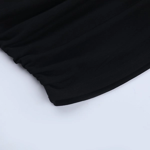 Détail du tissu froncé et des doubles surpiqûres sur le bas d'un caraco noir élégant
