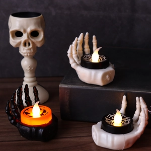 Halloween skeleton hand LED tea light holders on vintage books for table decor