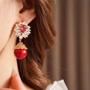 Gros plan de boucles d'oreilles fleurs vintage avec zircon rouge et cristaux sur un mannequin