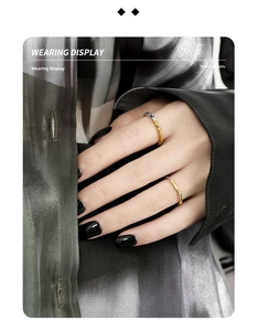 Detail view of two gold textured rings with organic molten lava surface on fingers