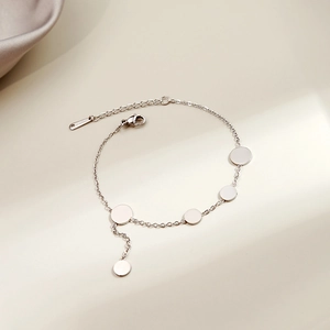 Macro shot of silver geometric heart charm bracelet with lobster clasp and extension chain
