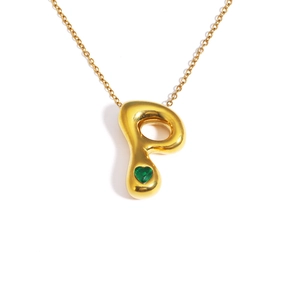 Close-up of golden letter P pendant with a green heart-shaped gemstone detail