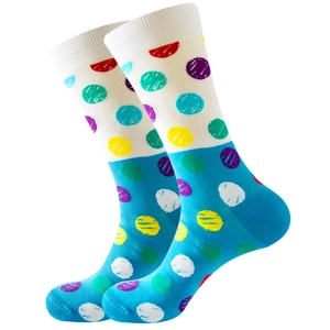 Close-up of white and blue knit mid-calf socks with colorful vibrant polka dots