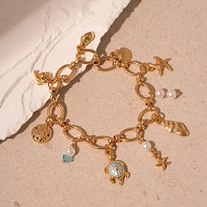 Detailed close-up of golden ocean bracelet with turtle, starfish and sea shell charms