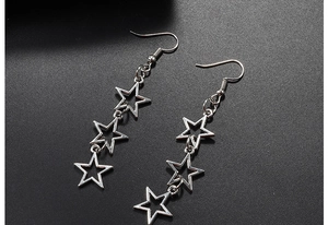 Detailed view of silver hollow star drop earrings featuring three tiered pentagrams
