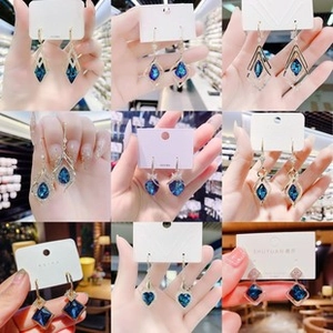 Detailed grid showing nine unique blue crystal gold dangle earring designs for women