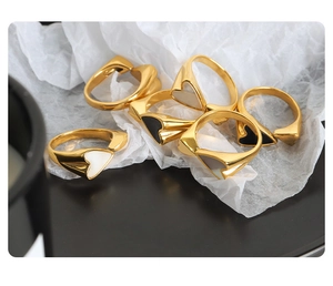 Macro shot of 18k gold plated titanium heart rings on artistic white pleated paper