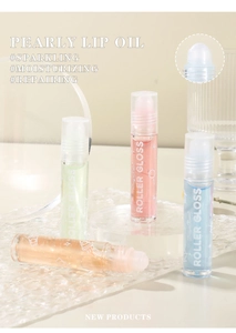 Detail view of pearly lip oil roller set with clear glass texture and glitter shine