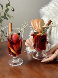 Close-up of mulled wine in elegant glasses with fresh fruit slices and cinnamon sticks