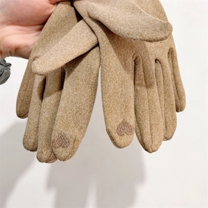 Detail of brown knit gloves with heart embroidery on index finger for touchscreen
