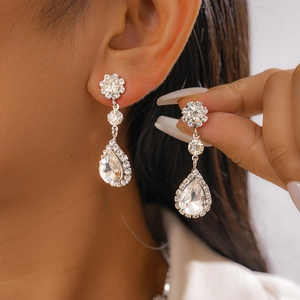 Gros plan d'élégantes boucles d'oreilles argentées avec zircons portées par un modèle