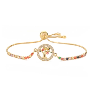 Adjustable gold tree of life bracelet with colorful stones and evil eye charms on white background