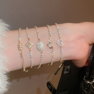 Close-up of a 5-piece gold bracelet set with zircon charms and sparkling crystals