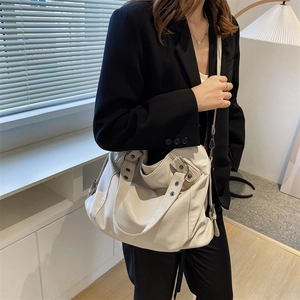 Minimalist beige canvas tote bag with large capacity, shown on a female fashion model