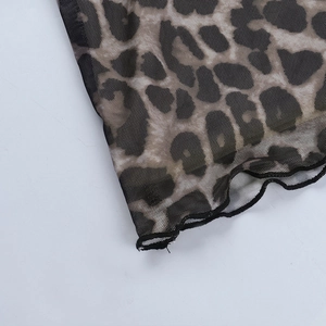 Détail du tissu en maille léopard montrant la transparence et les coutures de l'ourlet