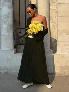 Detail of high-waist black pleated maxi skirt and cropped top for summer vacation style