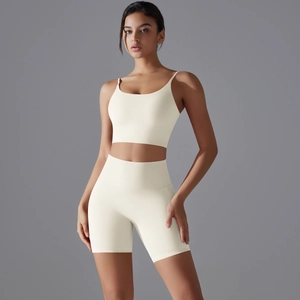Dettaglio del set pantaloncini yoga a vita alta e reggiseno sportivo in bianco crema