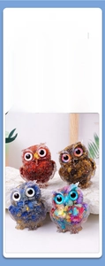 Detail of four colorful resin owls with crystal fragments and gold foil fillings