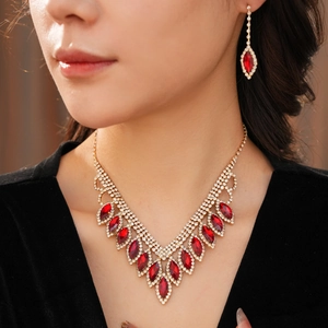 Close-up of elegant gold necklace and red teardrop earrings worn by a model