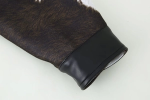 Detail of animal print faux fur sleeve with black leather trim on a short jacket