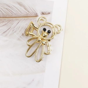 Detailed view of a gold astronaut metal hair claw clip with black bead accents
