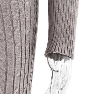 Detail eines grauen Strickpullovers mit Zopfmuster und gerippten Bündchen am Ärmel