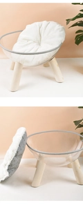 Detail view of transparent acrylic cat bed with solid wood legs and white plush cushion