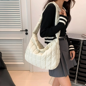 Model wearing a medium beige quilted cotton tote bag in a minimalist indoor setting